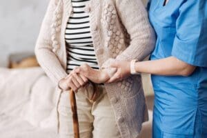 A qualified healthcare professional helping an elderly patient